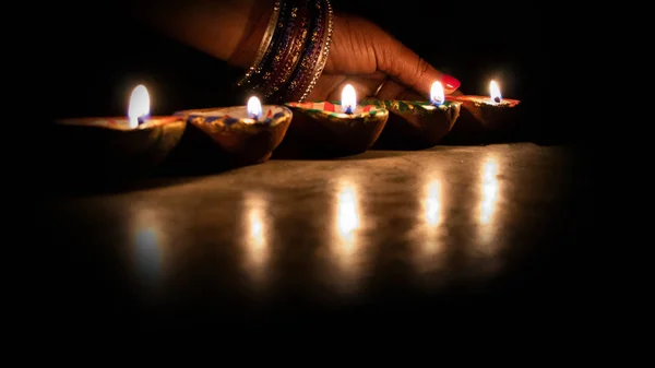 Bir kibrit çöpü aydınlatma diya lambalar diwali kutlamaları sırasında - görüntü tutan el