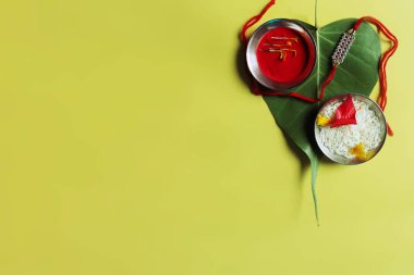 Raksha Bandhan Rakhi çiçek, pirinç ve kumkum ile, Raksha Bandhan veya Rakshabandhan yeşil manevi Banyan ağaç yaprağı üzerinde Hint Festivali üst görünümü vurdu 