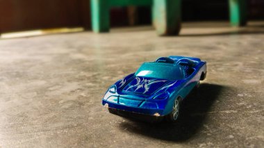Seçici odaklı bir araba oyuncak. Farklı arka plandaki çocuklar için mavi oyuncak araba yakın çekim.