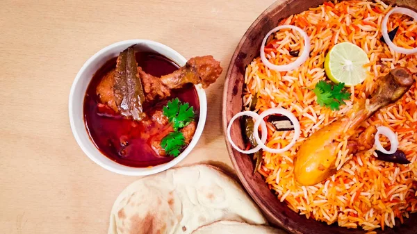 チキンカレーマサラスパイシーなカレー肉料理は 木製の背景にナンパンと白いボウルに 伝統的な背景 インドやパキスタンの食べ物に木製のボウルでおいしいスパイシーなチキンビリヤニ — ストック写真