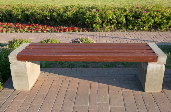 a concrete bench stands in the park