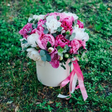 Hediye çiçek kutusu. Birçok beyaz ve pembe peonies çiçekler ve kurdeleler ile dekore edilmiş kağıt şapka Okaliptüs yaprakları.