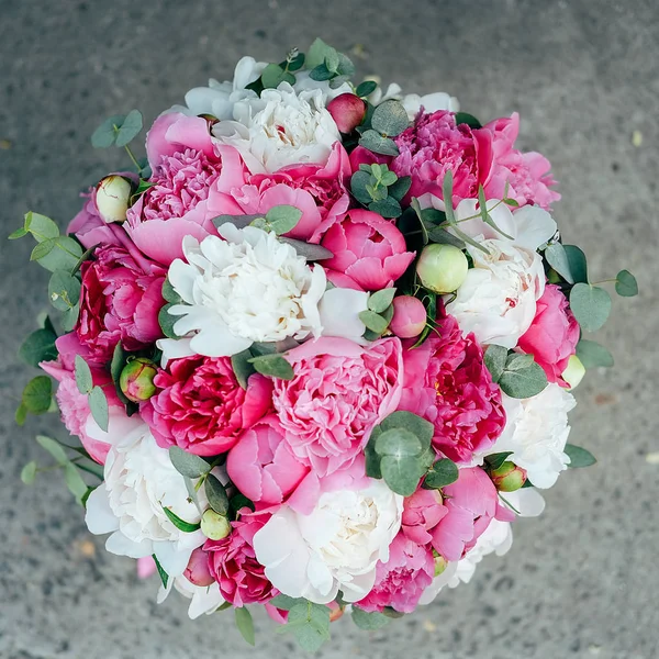 Gift flower box. Many white and pink peonies flowers and eucalyptus leaves in paper hatbox decorated with ribbons.