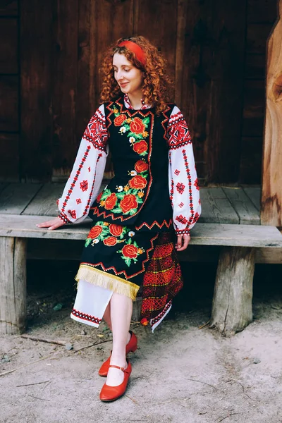 Genç Slavonic Kadın Geleneksel Işlemeli Kostüm Verandada Oturan Kırmızı Ayakkabılar — Stok fotoğraf
