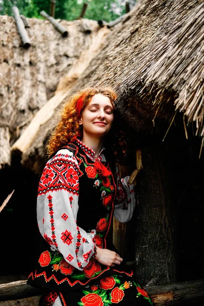 Genç Slavonic kadın geleneksel işlemeli kostüm ve verandada oturan kırmızı ayakkabılar