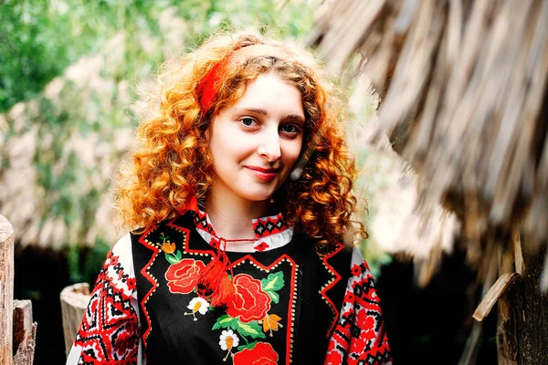 Genç Slavonic kadın geleneksel işlemeli kostüm ve verandada oturan kırmızı ayakkabılar