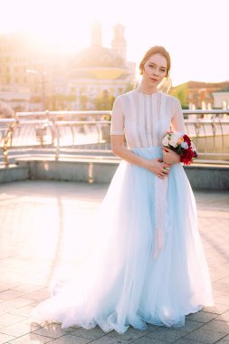 Gelin Gelinlik ve buket sokakta duran güzel günbatımı portresi