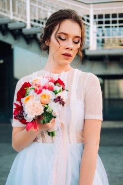 Gelin Gelinlik ve buket sokakta duran güzel günbatımı portresi