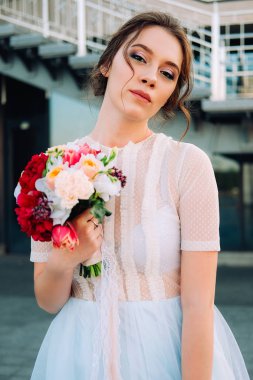 Gelin Gelinlik ve buket sokakta duran güzel günbatımı portresi