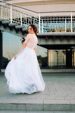 Gelin Gelinlik ve buket sokakta duran güzel günbatımı portresi