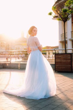 Gelin Gelinlik ve buket sokakta duran güzel günbatımı portresi