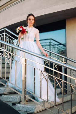 Gelin Gelinlik ve buket sokakta duran güzel günbatımı portresi