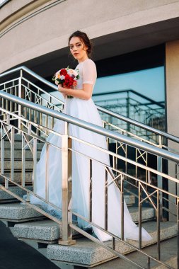 Gelin Gelinlik ve buket sokakta duran güzel günbatımı portresi