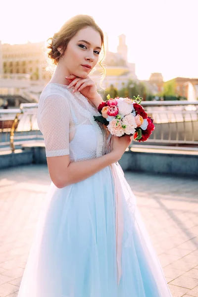 ウェディング ドレスとブーケ 通りに立っている花嫁の美しい夕日の肖像画 — ストック写真