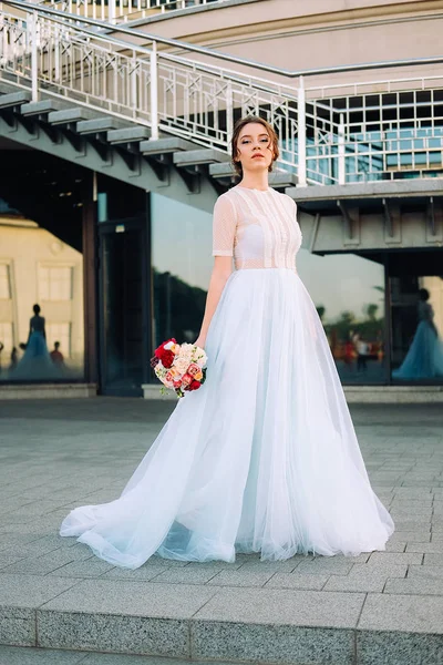 ウェディング ドレスとブーケ 通りに立っている花嫁の美しい夕日の肖像画 — ストック写真