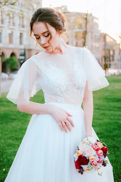 夏の夜に教会に歩いている白いドレスの魅力的な若い花嫁 — ストック写真