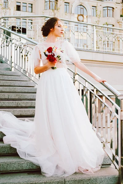 レースとチュール夕日で階段を踏んで作られたウェディング ドレスを流れる白の愛らしい白人花嫁 — ストック写真
