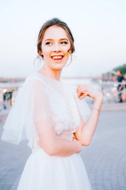 Beyaz akan içinde mutlu genç gelin elbise kendini açık havada zevk. Gelin makyaj ve saç.