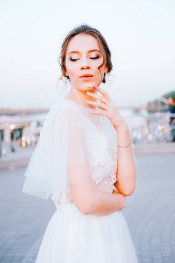 Beyaz akan içinde mutlu genç gelin elbise kendini açık havada zevk. Gelin makyaj ve saç.