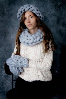 Kış moda aksesuarları. Soğuk havalarda gri kurdele, şapka ve eldiven giymiş genç kadın.