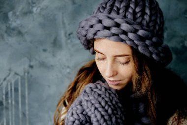 Kış moda aksesuarları. Soğuk havalarda gri kurdele, şapka ve eldiven giymiş genç kadın.