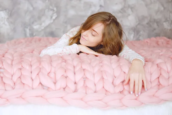 长棕色头发的年轻妇女睡觉在温暖的针织桃颜色投掷毯子 — 图库照片