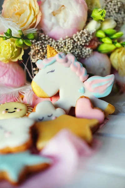 Gingerbread cookies covered with multi colored icing in pale pastel colors shaped as sun, cloud, star, unicorn