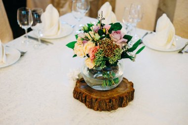 Düğün masa çiçek dekorasyonu. Cam vazo ile tablo sayı konuklar yeşillik, gül, lisianthus ve diğer çiçekler için.