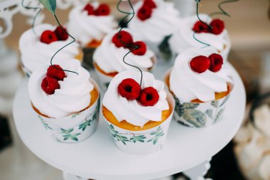 Ahududu ile tepesinde beyaz buzlanma ile tatlı lezzetli cupcakes