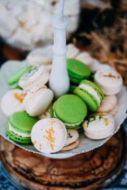Şeker çubuğu kavramı. Bir cam kase lezzetli yeşil ve beyaz macaroons.
