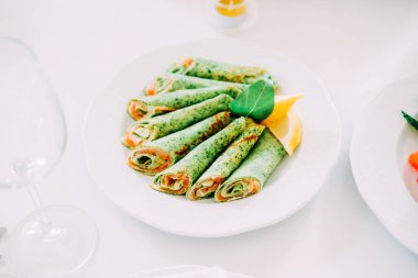 Beyaz tabakta Somon Balık ve peynir ile doldurulmuş krep ıspanak