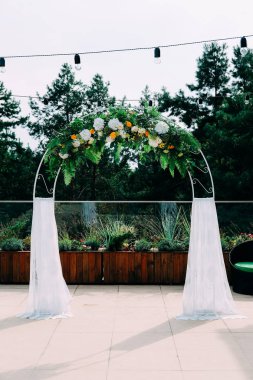Açık Hava düğün töreni. Beyaz ve sarı çiçekler ve dantel ile dekore edilmiş kemer.