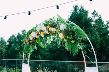 Açık Hava düğün töreni. Beyaz ve sarı çiçekler ve dantel ile dekore edilmiş kemer.