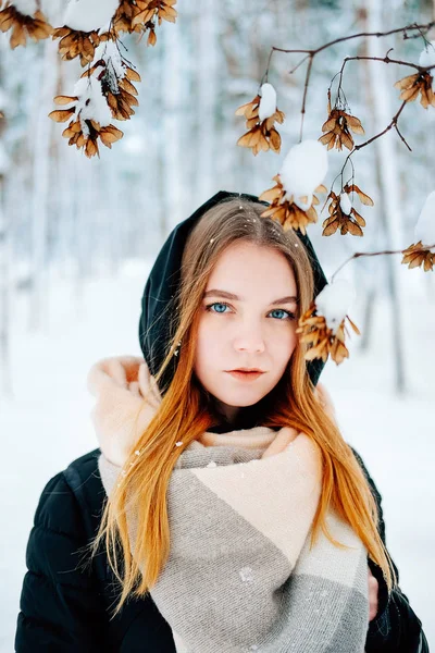 迷人的金发碧眼的年轻成年妇女走在冬季森林充满了雪穿着休闲服装的黑色帕卡 牛仔裤 粉红色皮靴和背包和米色披肩 — 图库照片