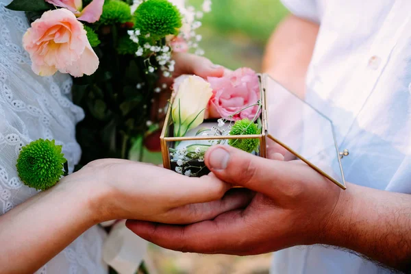 Par älskare håller en låda med vigselringar — Stockfoto