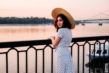 Genç bayan nehir teknesini bekliyor.