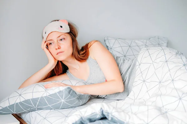 Woman with long hair in her bedroom sleeping on cozy soft pillow