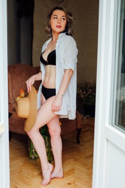 Kadın yatak odasında aynanın önünde giyiniyor.