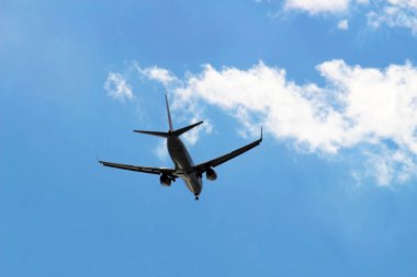 Mavi gökyüzünde uçan bir uçağın arka