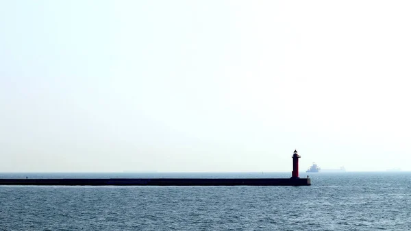 灯台が建つ港防波堤 — ストック写真