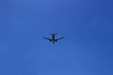 Berrak mavi gökyüzünde uçan jet uçağı