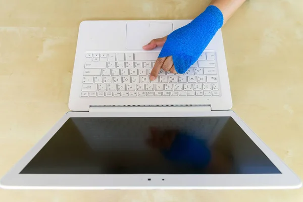 kadın mavi elastik bandaj ile el üstünde Laptop ofiste çalışan yaralı.