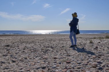 Denize vardığımızda nehrin akışını izleyen bir kadın.