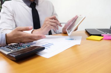 Businessman is using a pen for financial data analyzing counting