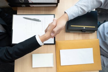 Businessmen making handshake in the office room