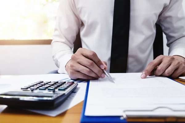 Businessman is using a pen for financial data analyzing counting