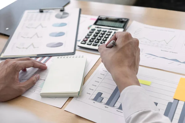 Businessman is analyzing business plans on the table in the offi