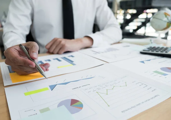 Businessman is analyzing business plans on the table in the offi