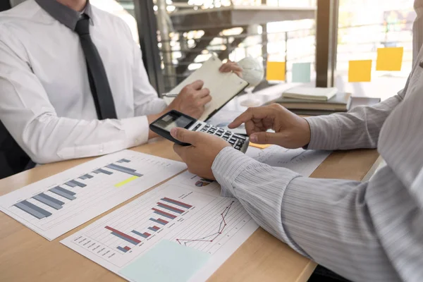 Two business people  are discussing about business graph on the 