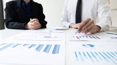 İki işadamı, ofis odasındaki satış performansı grafiği, finans ve muhasebe konseptinden pazarlama stratejisini tartışıyor ve analiz ediyor..